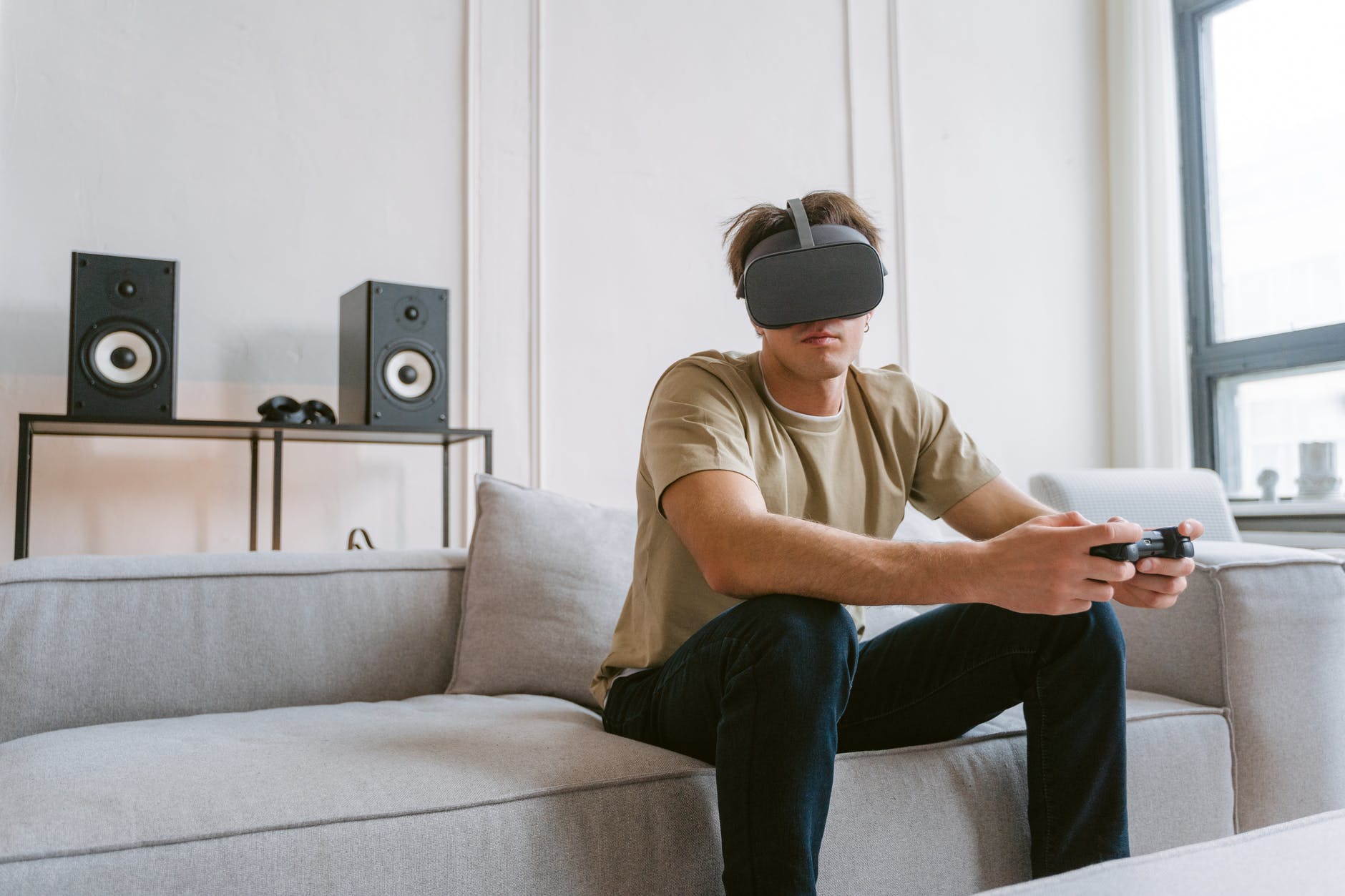 man sitting on a sofa while playing a virtual reality video game