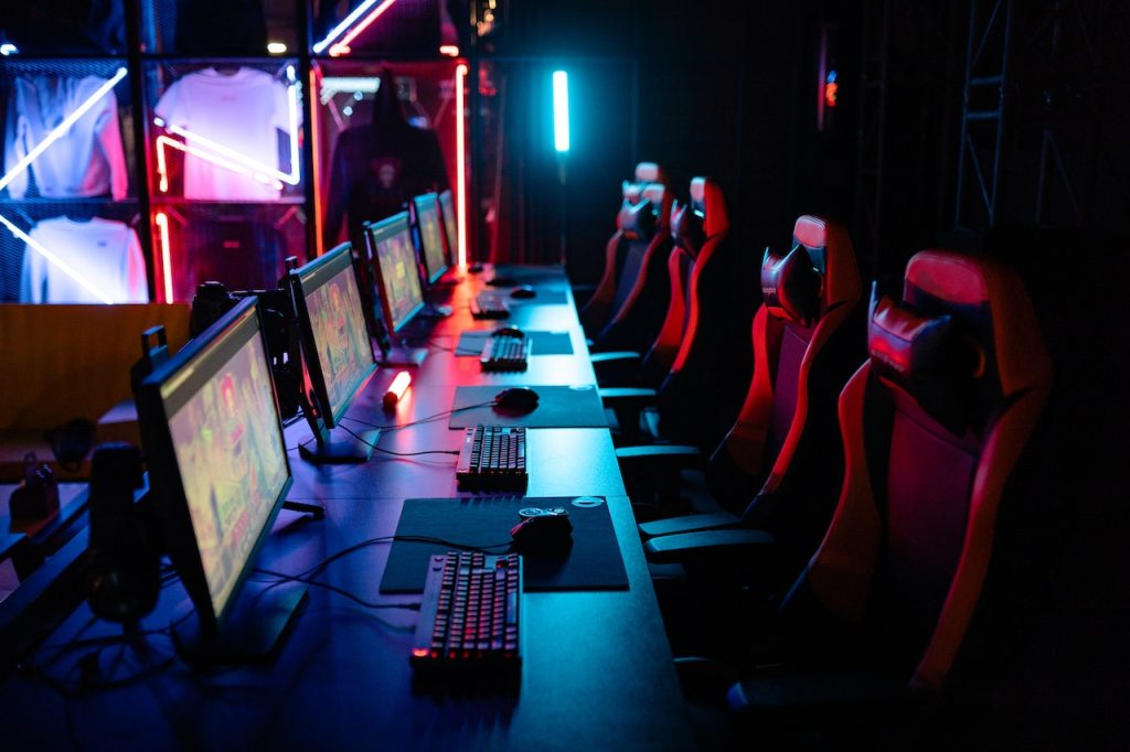 Empty chairs facing computer screens at an Esports tournament.