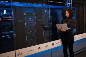 Woman on a laptop in front of a server data center