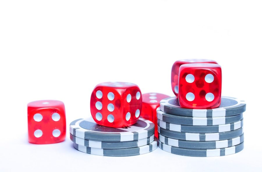 Dice on top of poker chips against a white background