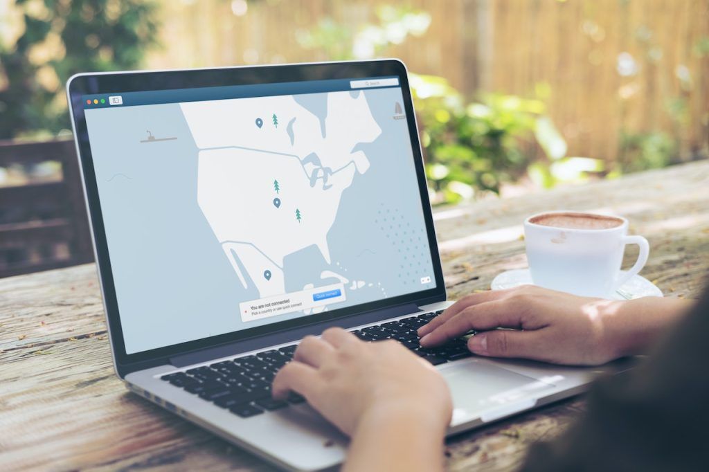 Laptop computer showing a map and user's hands typing