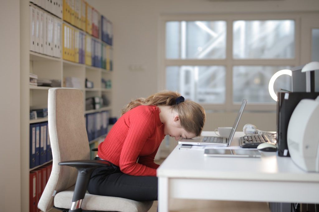 Seated woman with head down on laptop keyboard