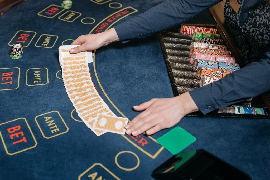 dealer's hands spreading out cards at a casino table