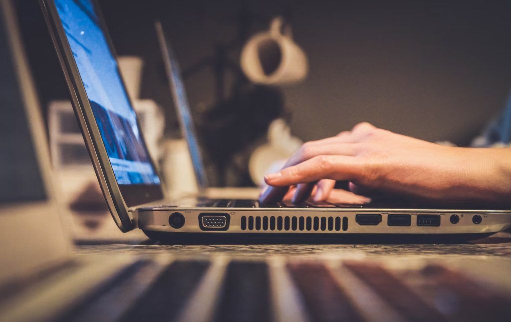 closeup of hands on a computer laptop keyboard