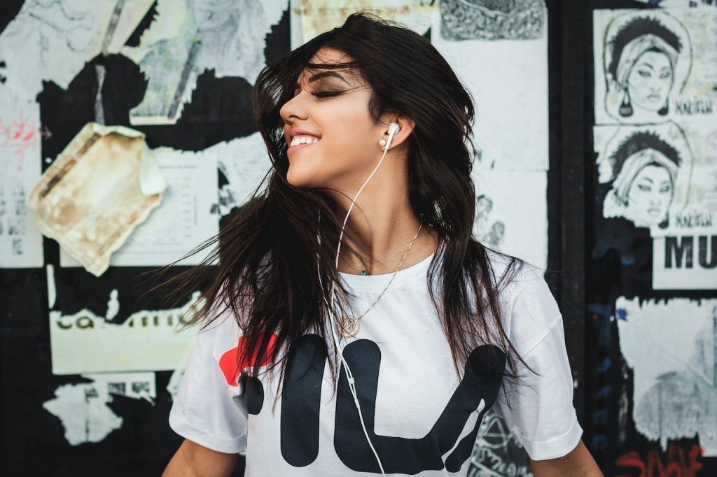 Woman listening to music against a wall