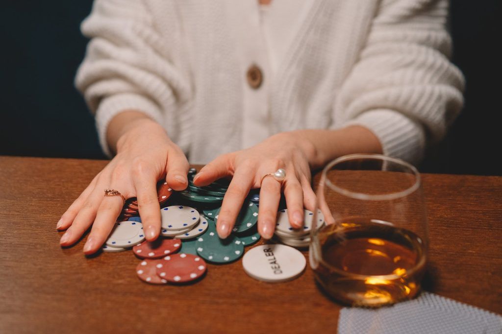 Woman with poker chips and a drink in front of her