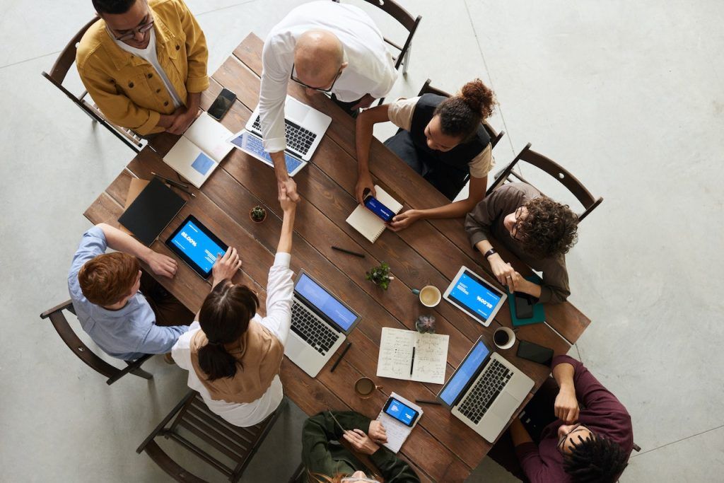 Overhead view of a multi-person business meeting around a conference table.