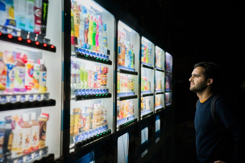 Man looking at large selections in many vending machines