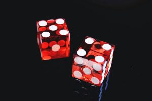 Two red six-sided dice on a black background