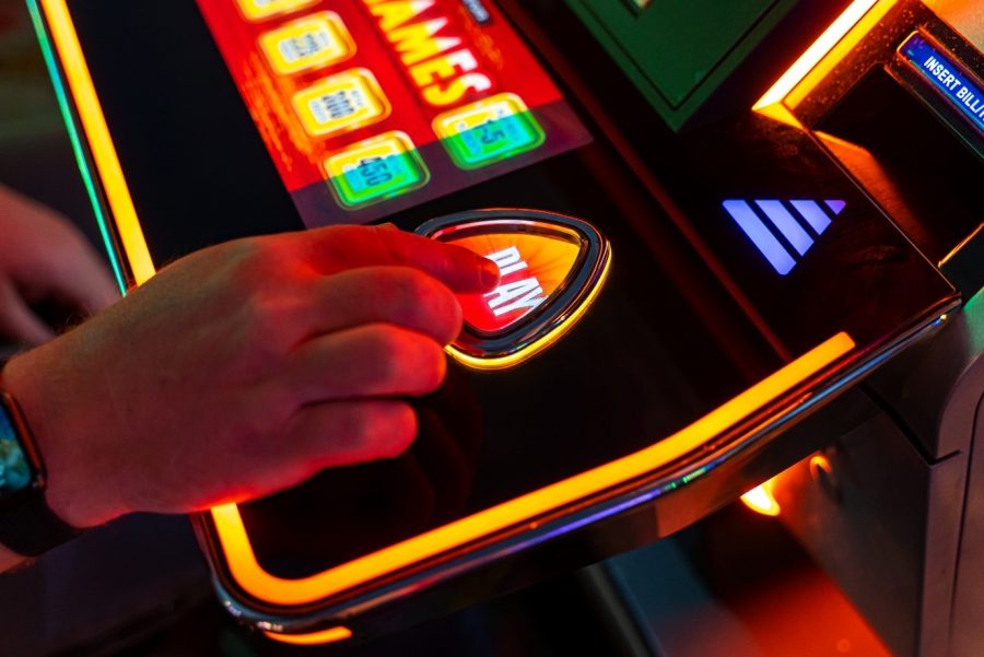 hand pressing the PLAY button on a slot machine - Stock ID 2350627581