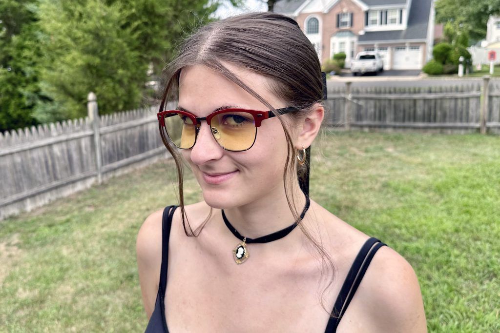 Diablo IV Sanctuary Edition Blood Onyx Amber Glasses worn by a woman outdoors