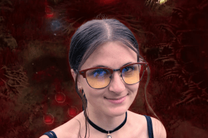 Diablo IV Sanctuary Edition Blood Onyx Amber Glasses worn by a woman in front of a Diablo IV background