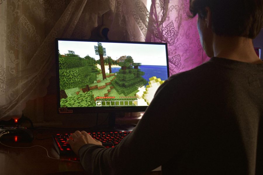 man playing Minecraft on a computer