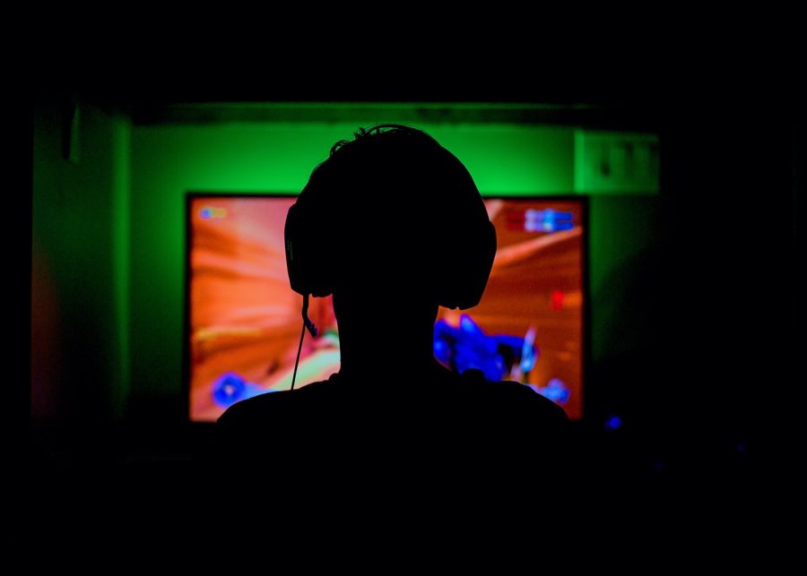 A Gamer playing in a dark room with a greenish glow