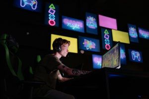 male gamer playing on a PC at a gaming cafe