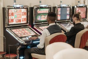 men sitting in front of slot machines