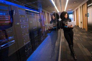 Engineer Holding Laptop in Front of Server Room