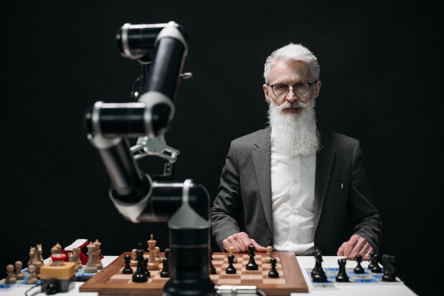 A Bearded Man Playing Chess Against a Robot Arm