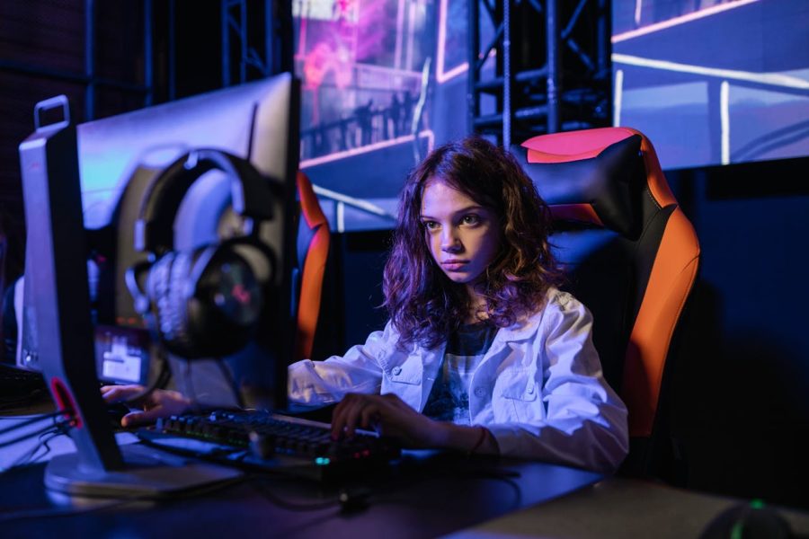 Woman in White Long Sleeve Shirt Sitting on Chair using Black Computer Keyboard