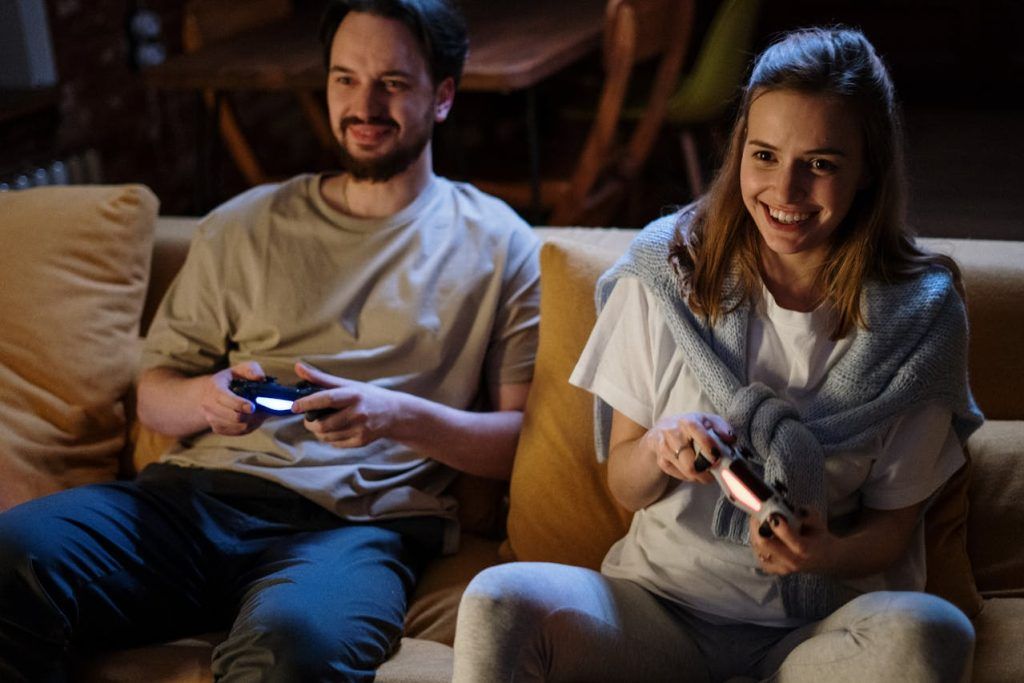 two adult gamers on a sofa