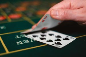 Close-up of hand lifting up a card in a blackjack game