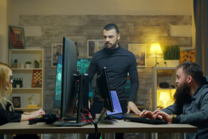 Three people working around computers and monitors