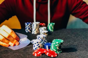 Man in front of playing cards and poker chips