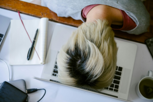 tired person resting on laptop
