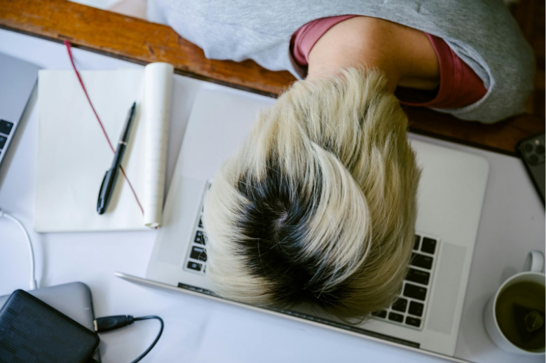 tired person resting on laptop