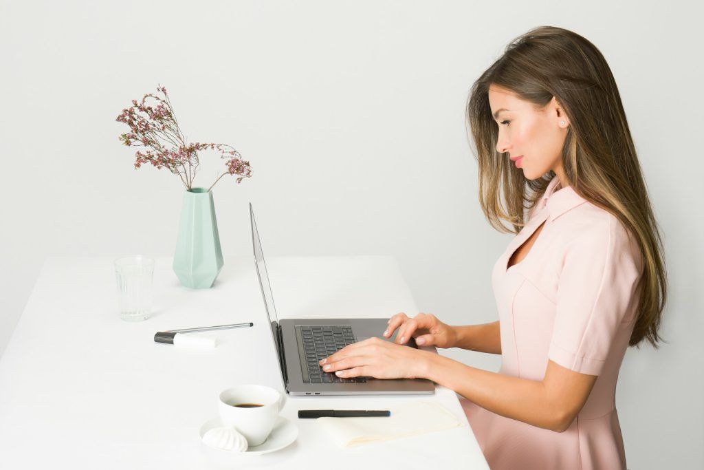 woman standing up working on laptop