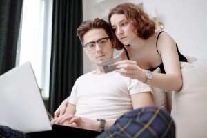 man typing credit card details provided by woman