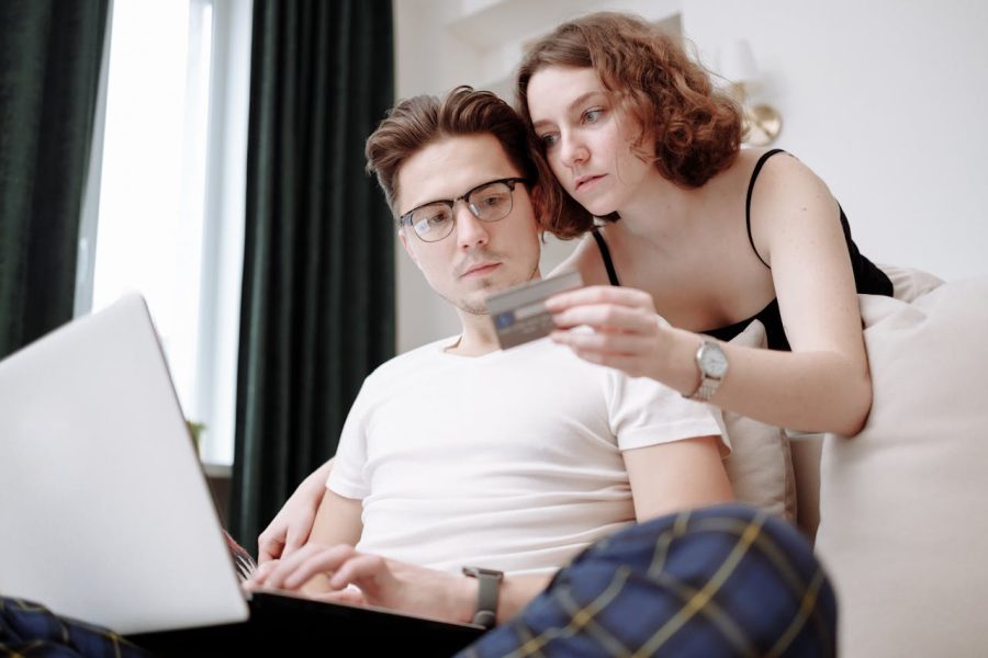 man typing credit card details provided by woman
