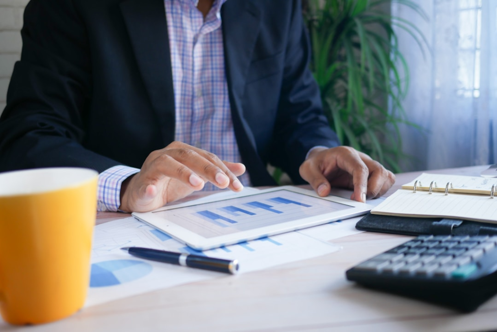A business professional analyzing bar graphs on a tablet, representing how data-driven decision-making is enhanced by predictive analytics through enterprise search for AI.
