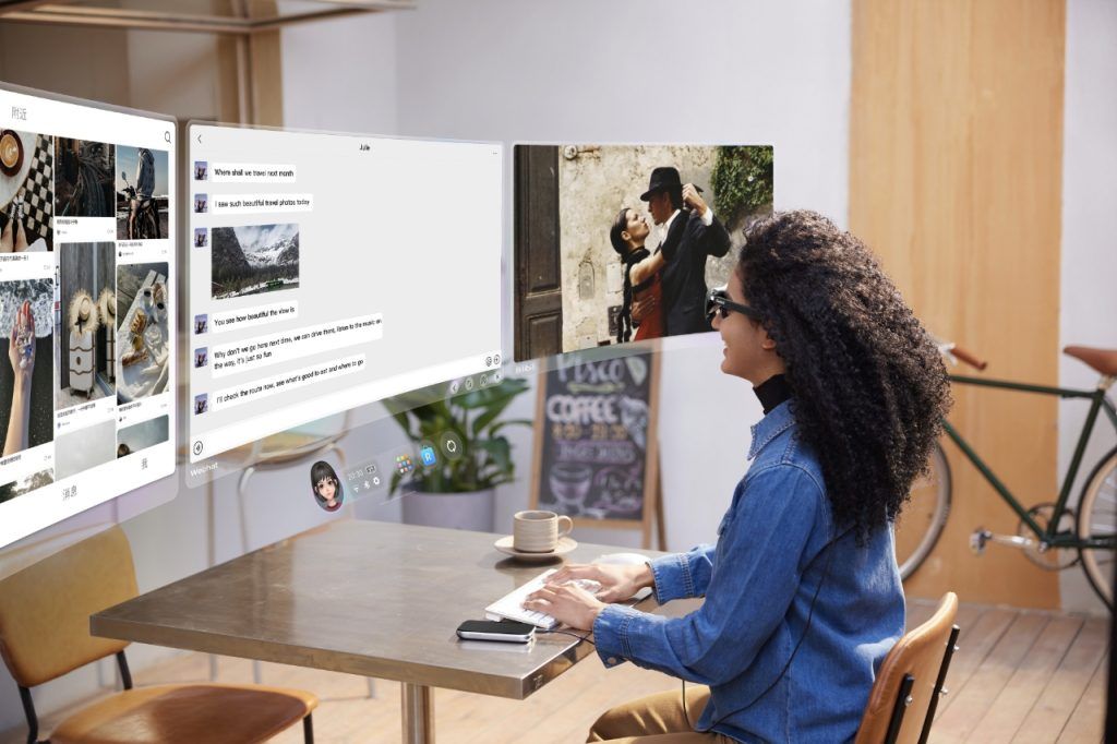 Woman computing with three virtual displays on the Rokid AR Spatial.