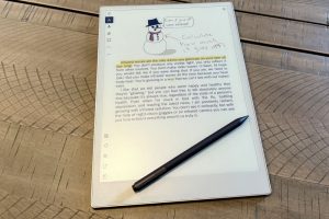 Remarkable Paper Pro with pen showing a color PDF with writing on it.