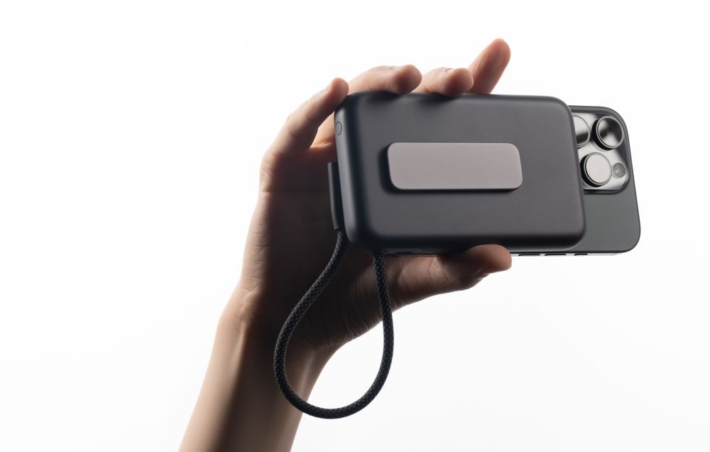 XREAL NEO attached to a smartphone and held by a hand.