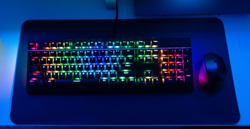 black keyboard with RGB lights next to a mouse