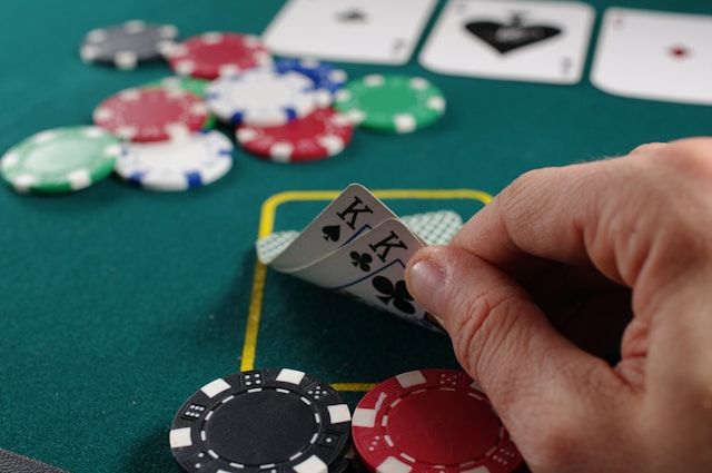 person looking at two King cards at casino table