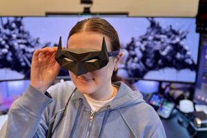 RayNeo Air 4 Pro AR glasses with Batman shade being worn by a young woman.