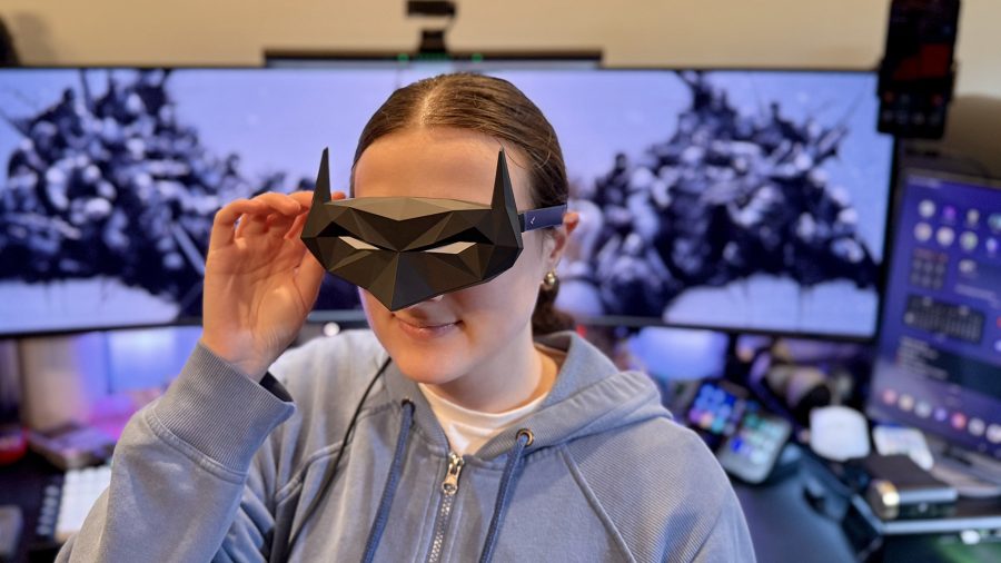 RayNeo Air 4 Pro AR glasses with Batman shade being worn by a young woman.